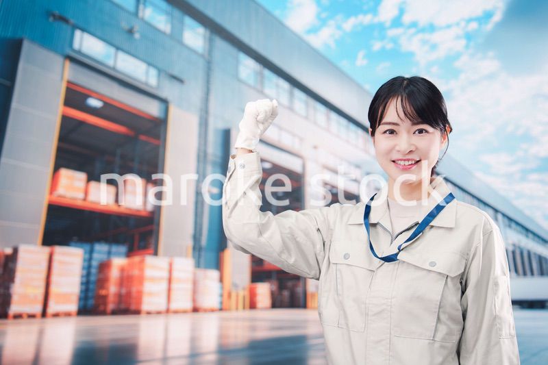 物流拠点で働く作業服姿の若い女性