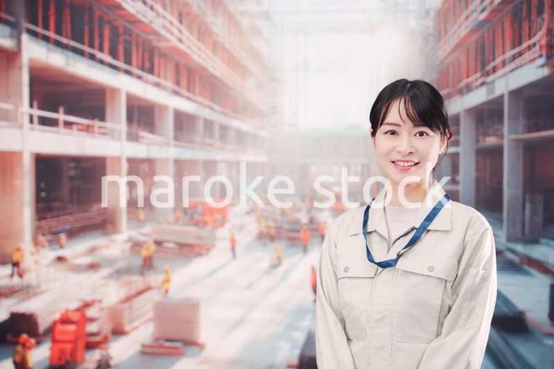 ビルの建築現場で働く作業着を着た若い女性