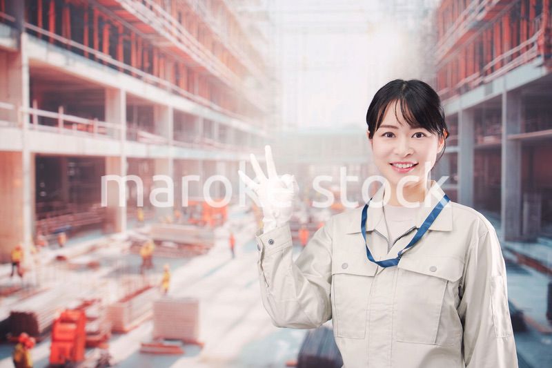 ビルの建築現場で働く作業着を着た若い女性