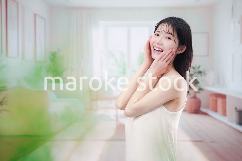 部屋でスキンケアをする若い女性