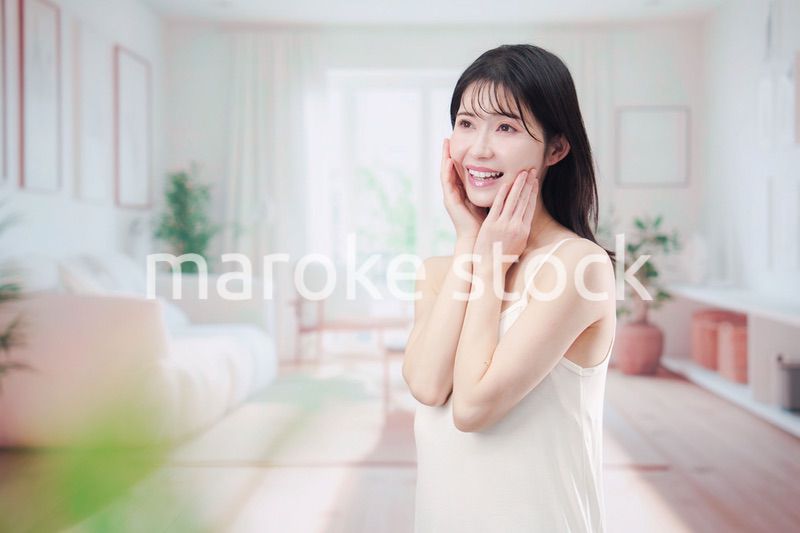 部屋でスキンケアをする若い女性