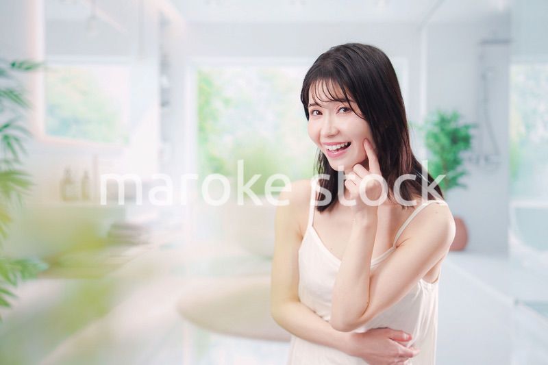 バスルームでスキンケアをする若い女性