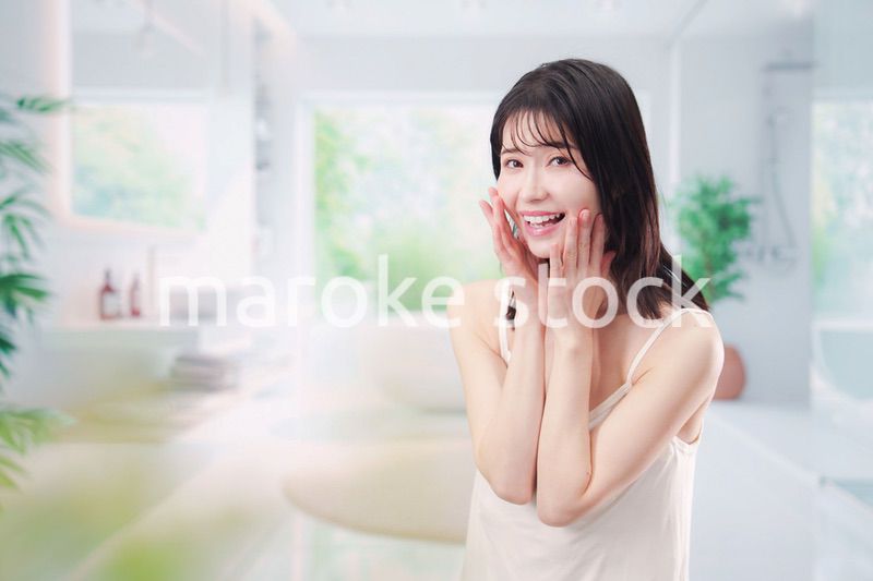 バスルームでスキンケアをする若い女性