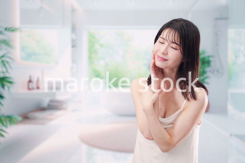 バスルームでスキンケアをする若い女性