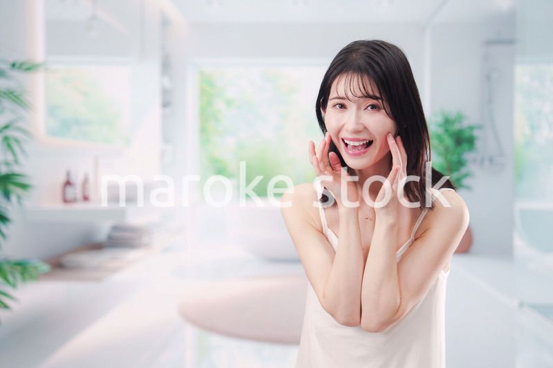 バスルームでスキンケアをする若い女性