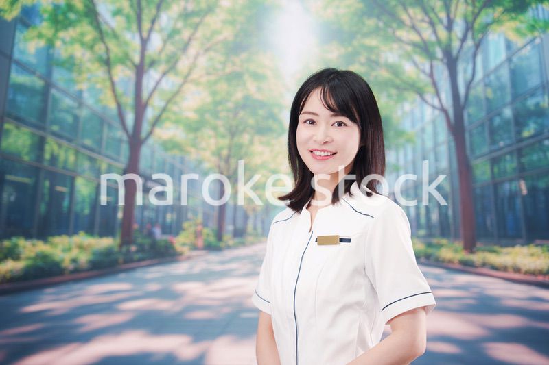 白衣を着て笑顔で外を歩く医療従事者の若い女性