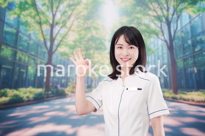 白衣を着て笑顔で外を歩く医療従事者の若い女性