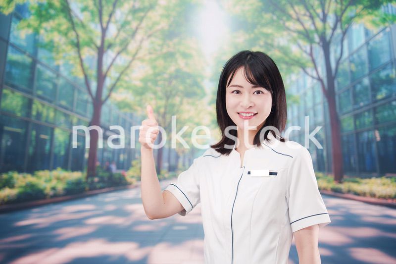 白衣を着て笑顔で外を歩く医療従事者の若い女性