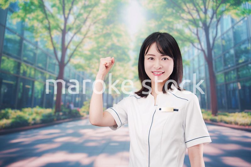 白衣を着て笑顔で外を歩く医療従事者の若い女性