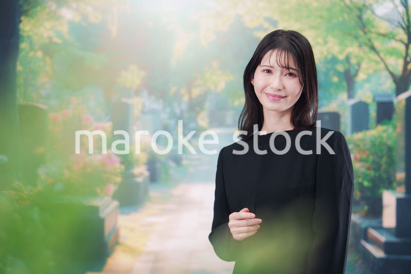 喪服を着てお墓参りをする女性