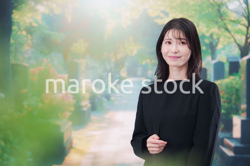 喪服を着てお墓参りをする女性