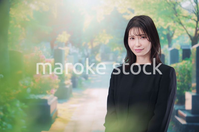 喪服を着てお墓参りをする女性