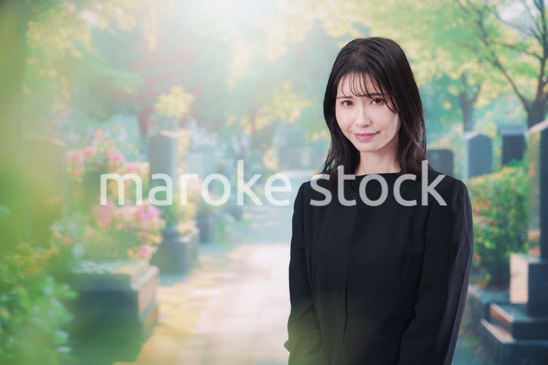 喪服を着てお墓参りをする女性