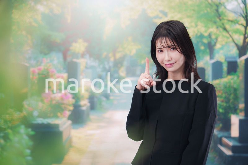 喪服を着てお墓参りをする女性