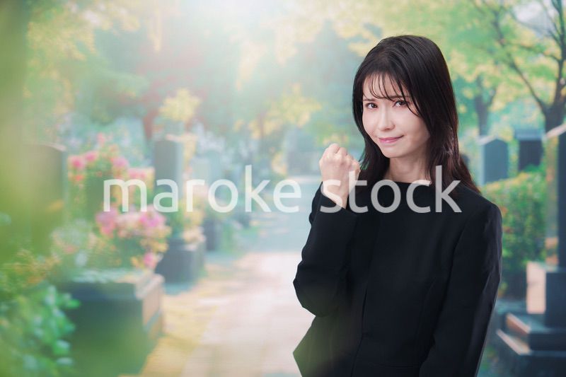 喪服を着てお墓参りをする女性
