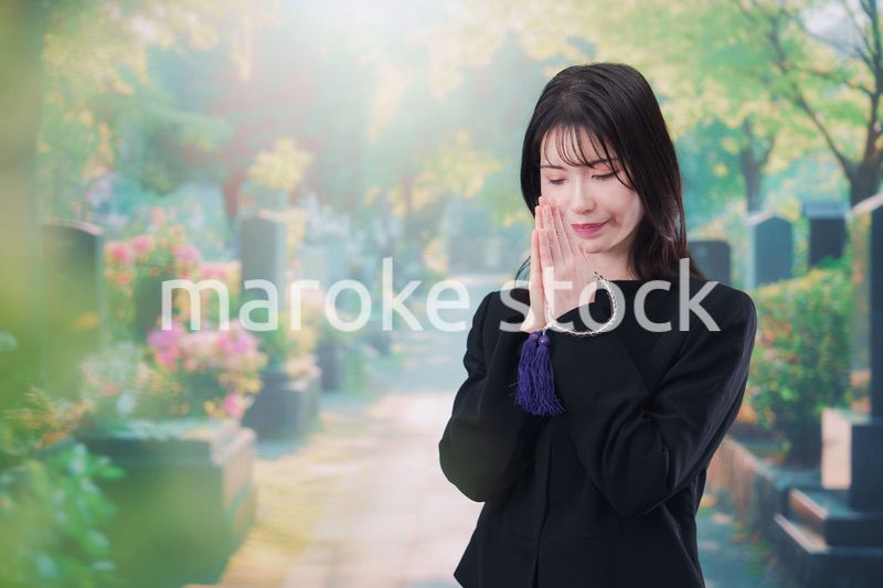 喪服を着てお墓参りをする女性