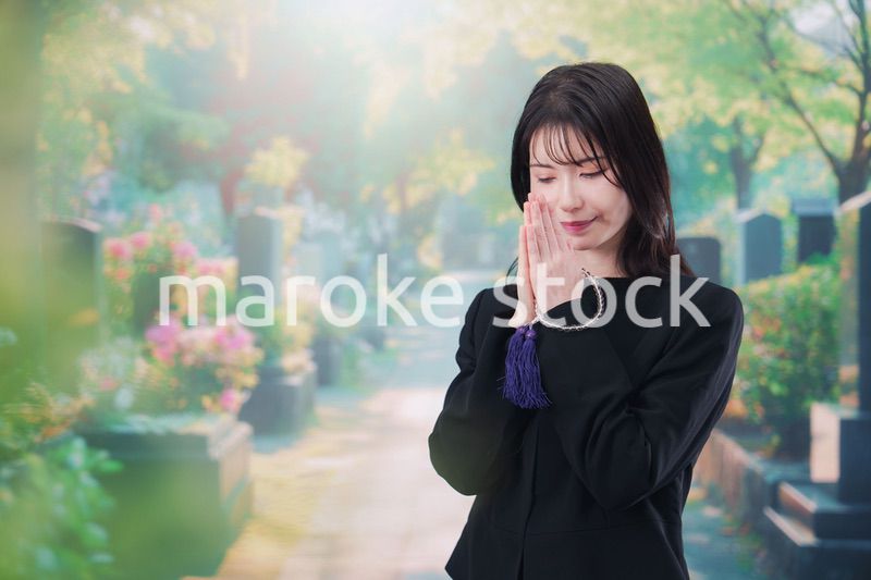 喪服を着てお墓参りをする女性