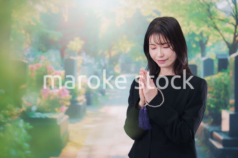 喪服を着てお墓参りをする女性