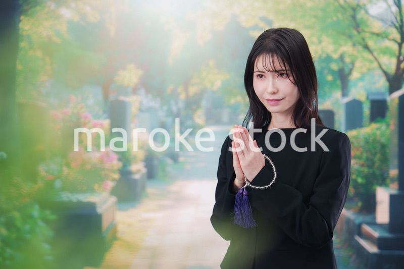 喪服を着てお墓参りをする女性