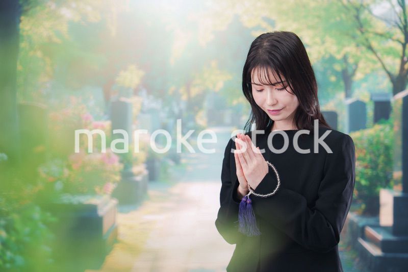 喪服を着てお墓参りをする女性