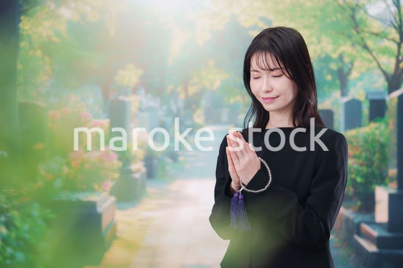 喪服を着てお墓参りをする女性