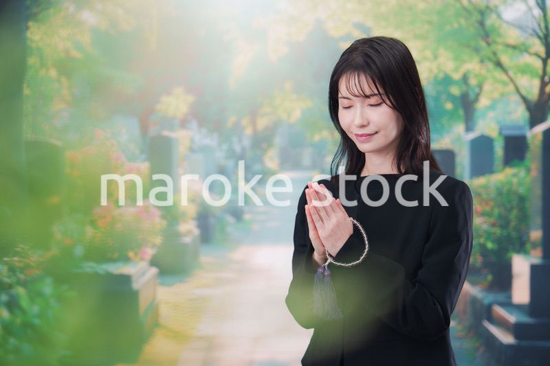 喪服を着てお墓参りをする女性