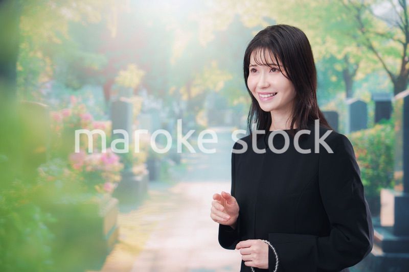 喪服を着てお墓参りをする女性