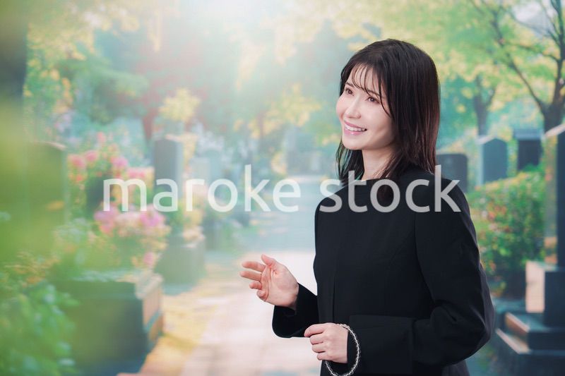 喪服を着てお墓参りをする女性