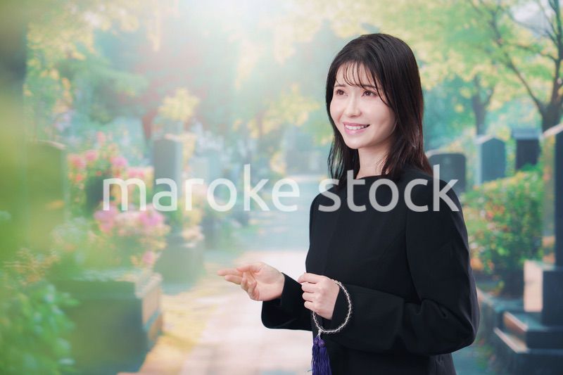 喪服を着てお墓参りをする女性