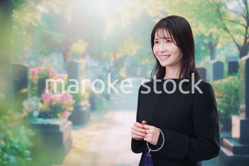 喪服を着てお墓参りをする女性