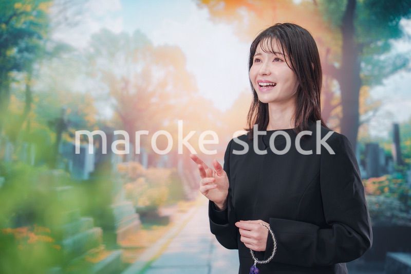 喪服を着てお墓参りをする女性