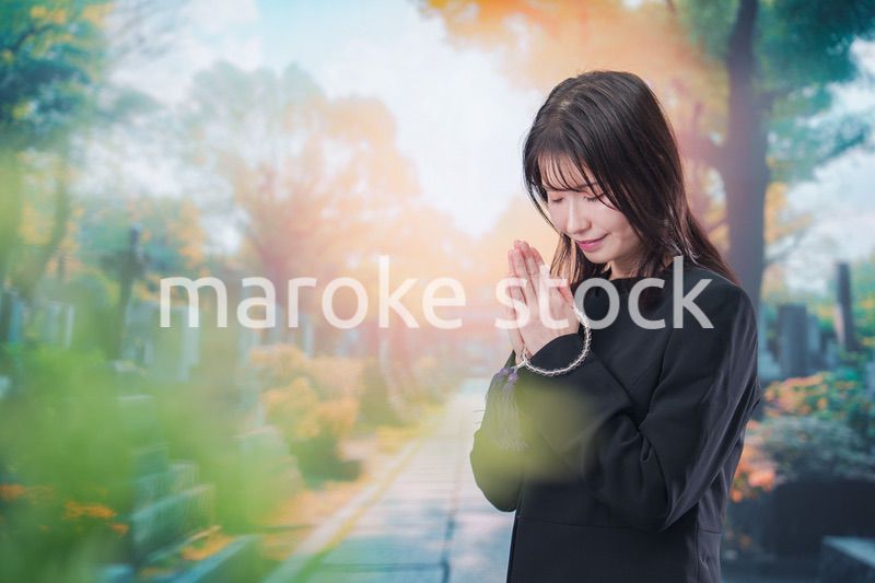 喪服を着てお墓参りをする女性