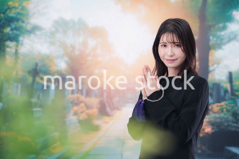 喪服を着てお墓参りをする女性