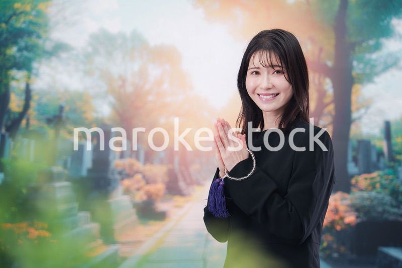 喪服を着てお墓参りをする女性