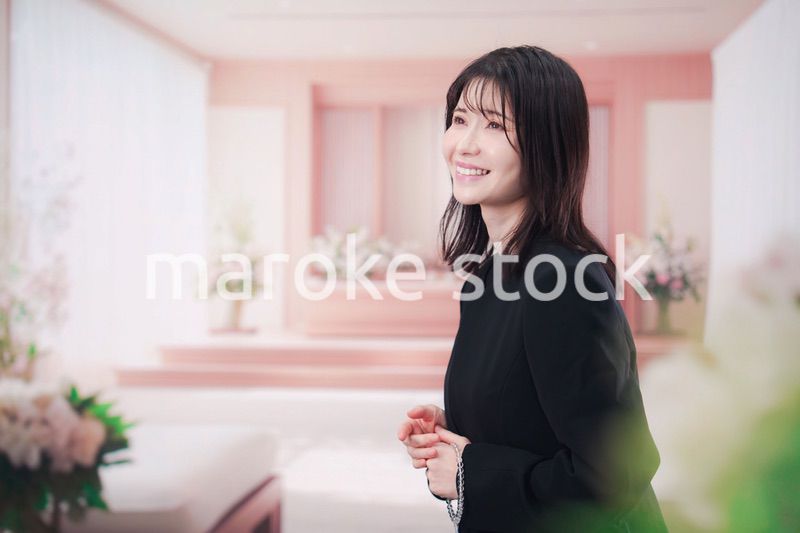 お葬式で喪服を着て数珠を持つ若い女性