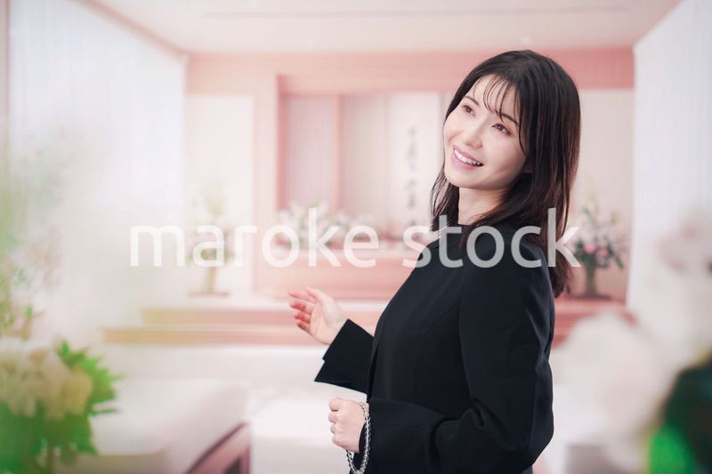 お葬式で喪服を着て数珠を持つ若い女性