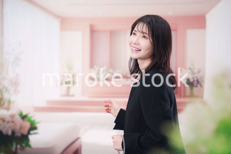 お葬式で喪服を着て数珠を持つ若い女性