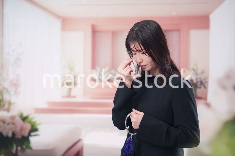 お葬式でお焼香をする女性の参列者