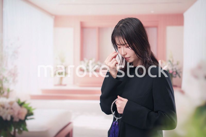 お葬式でお焼香をする女性の参列者