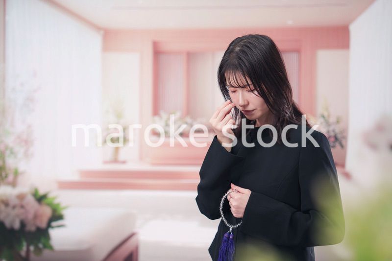 お葬式でお焼香をする女性の参列者