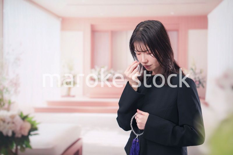 お葬式でお焼香をする女性の参列者