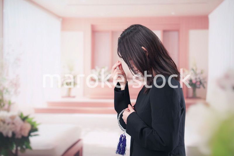 お葬式でお焼香をする女性の参列者