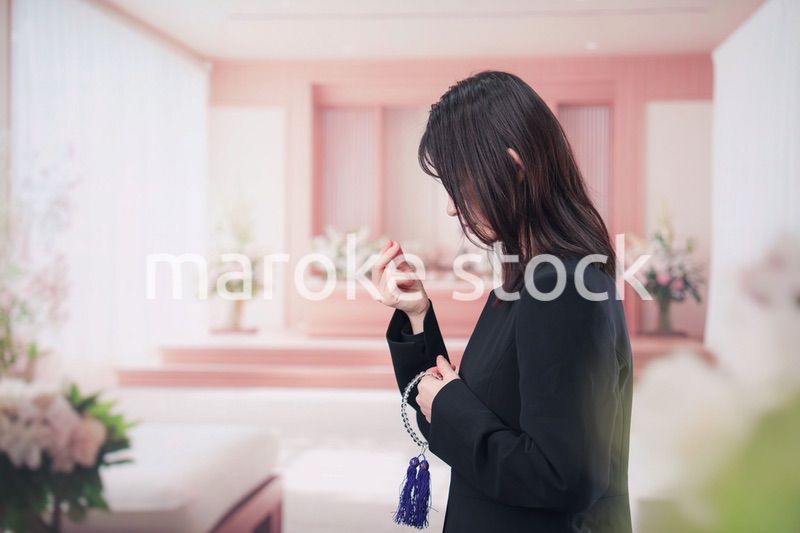 お葬式でお焼香をする女性の参列者
