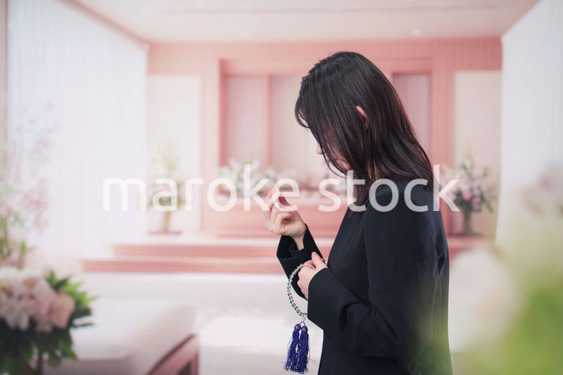 お葬式でお焼香をする女性の参列者