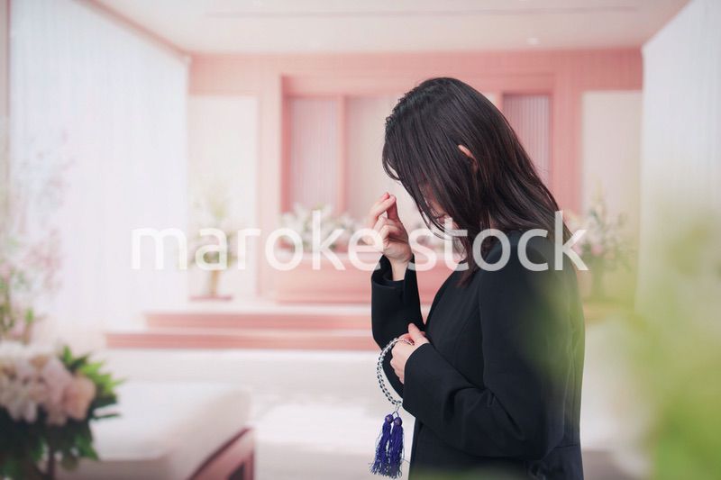 お葬式でお焼香をする女性の参列者