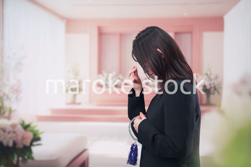 お葬式でお焼香をする女性の参列者