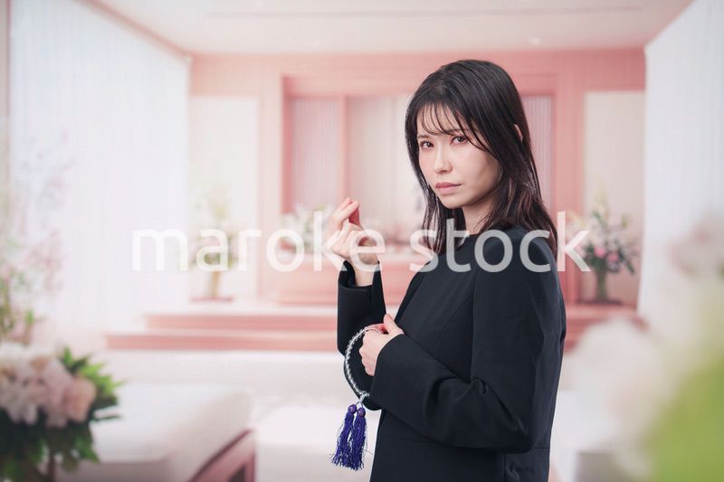 お葬式でお焼香をする女性の参列者