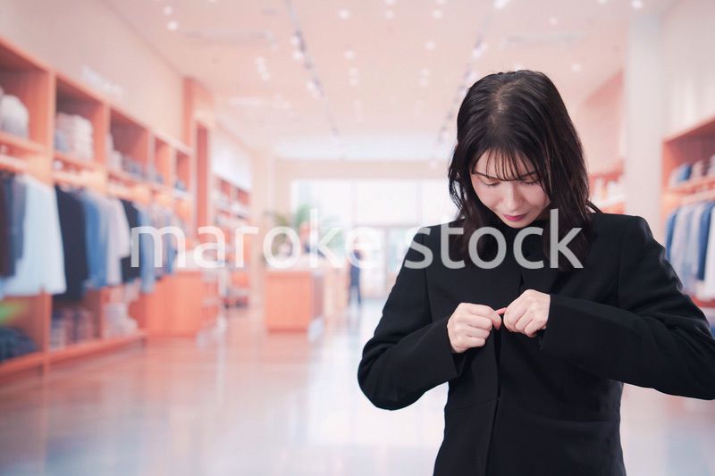アパレル店で服のフィッティングをする若い女性