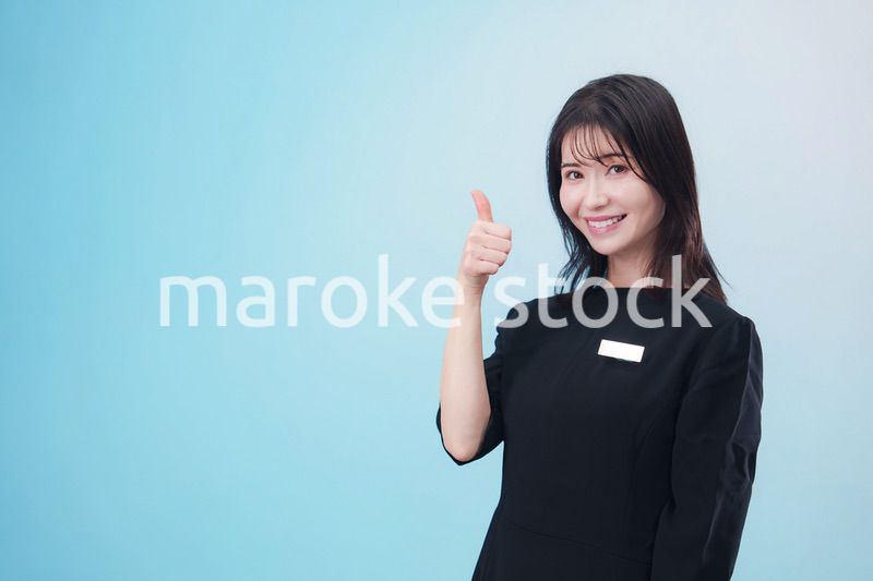 黒い服に名札をつけた笑顔のスタッフ（水色背景）