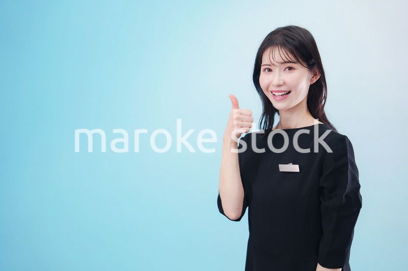 黒い服に名札をつけた笑顔のスタッフ（水色背景）